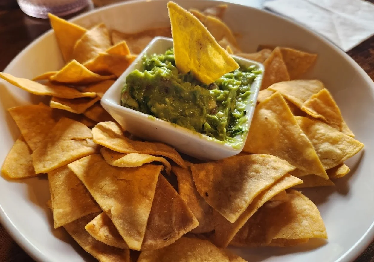Nachos at Taqueria El Chingon Edmonton - Homemade corn chips with nacho cheese, sour cream, pico de gallo, feta, and jalapeños